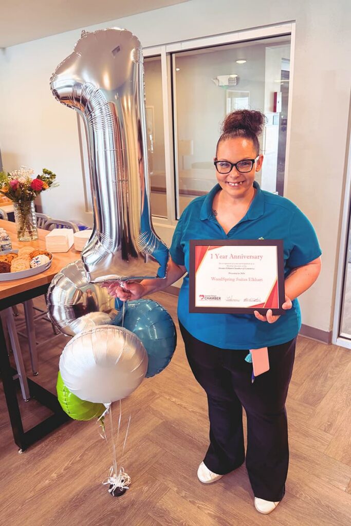 WoodSpring Suites Elkhart General Manager accepts a plaque from the Chamber of Commerce in celebration of the hotel's first anniversary.